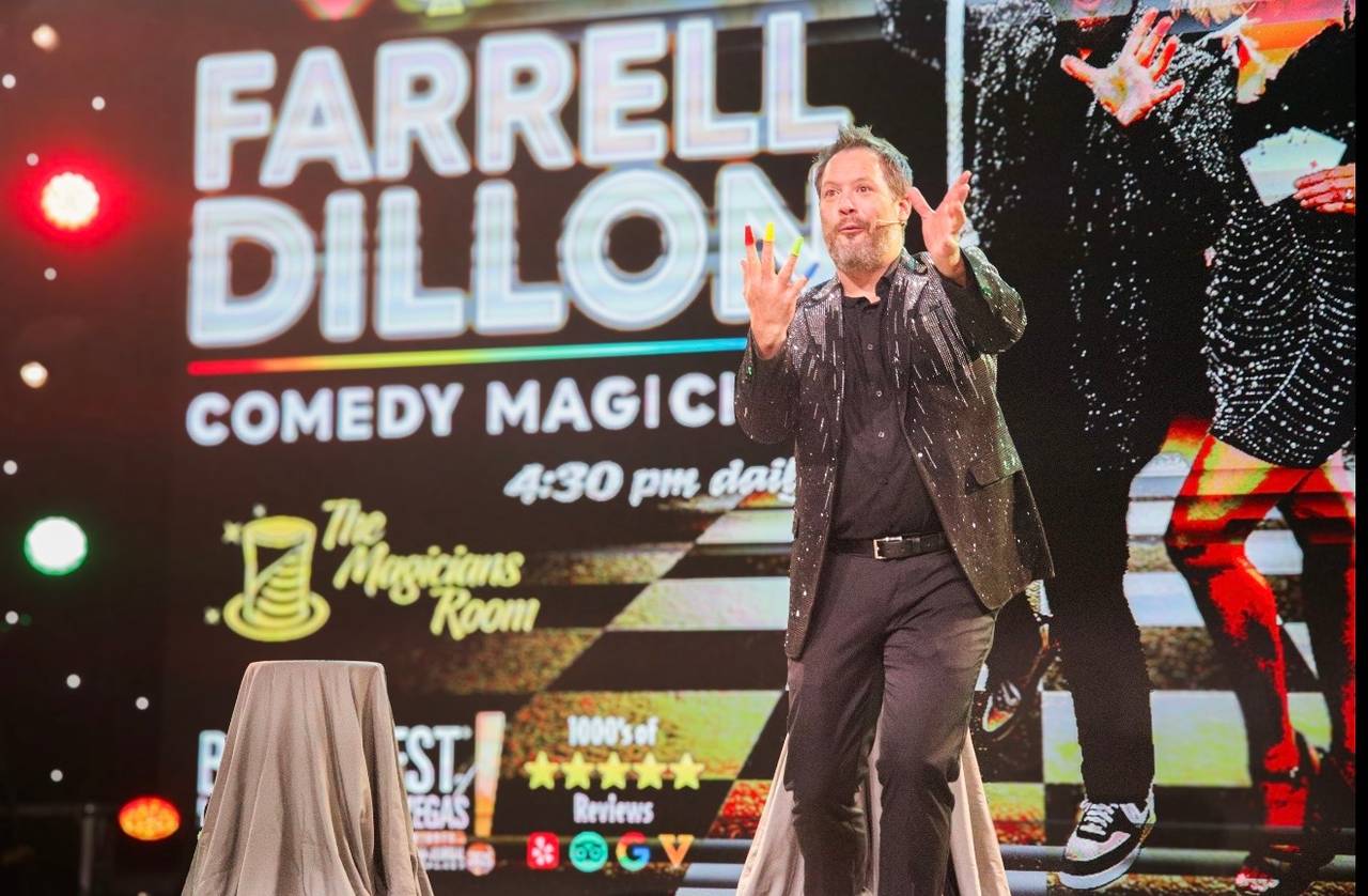 Farrell Dillon performing on stage in front of a large screen showing his name