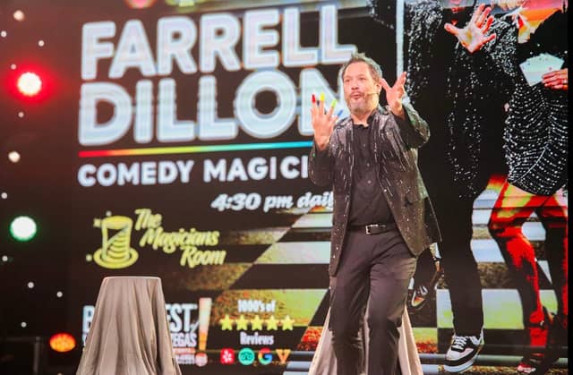 Farrell Dillon performing beneath his Comedy Magic stage sign