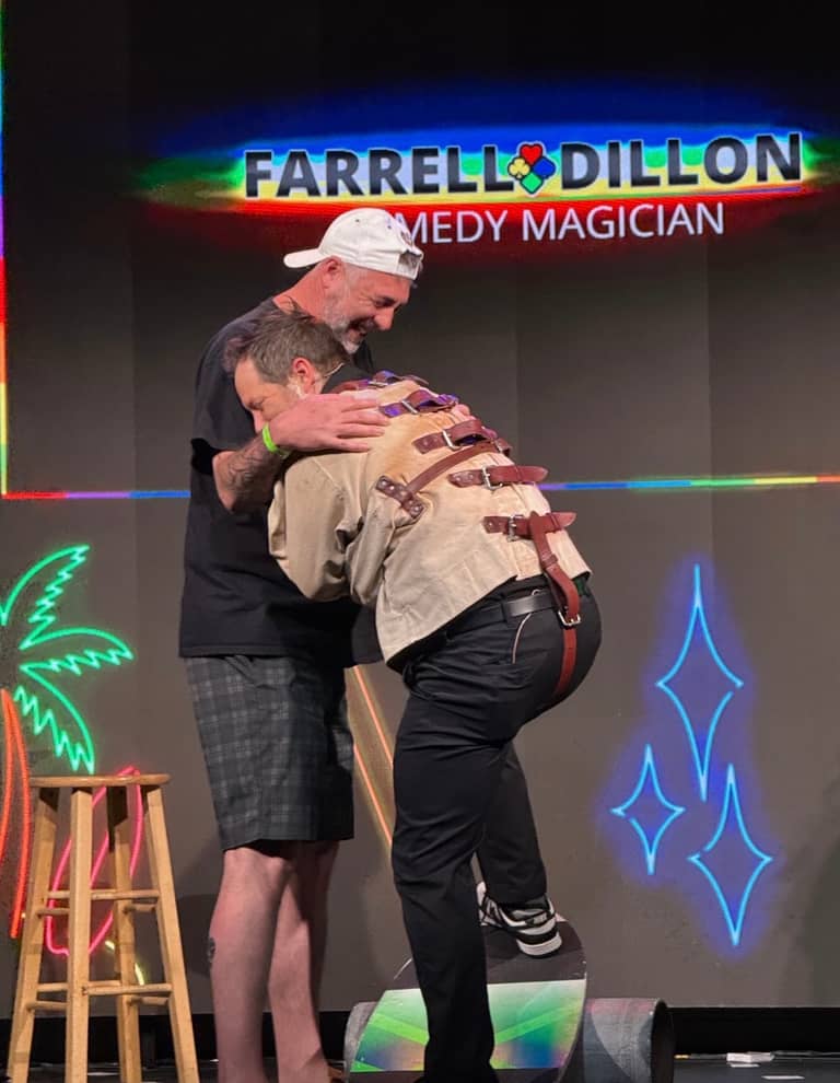 Farrell Dillon strapping an audience member into a straitjacket