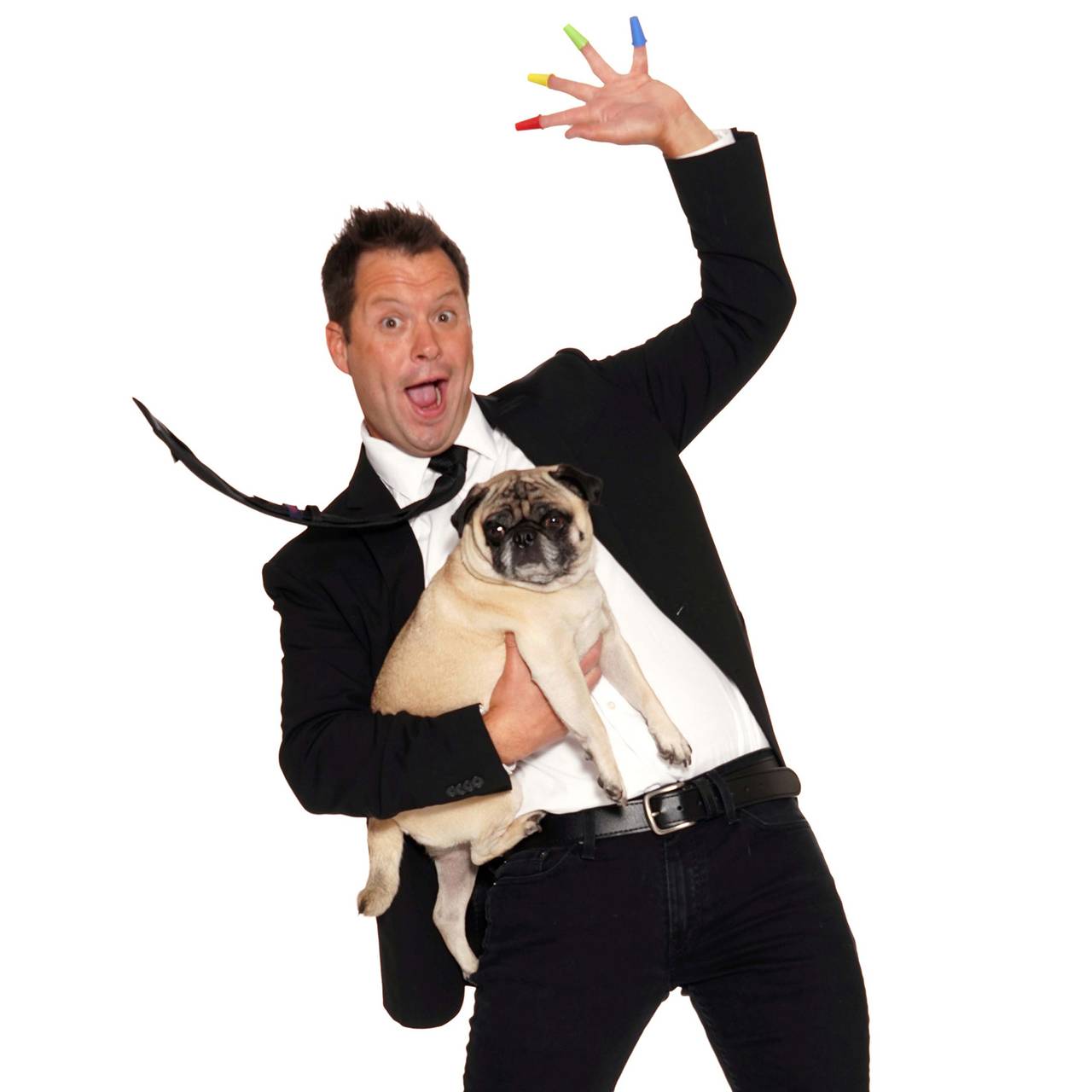 Farrell Dillon in a tuxedo holding his pug, mid-gag