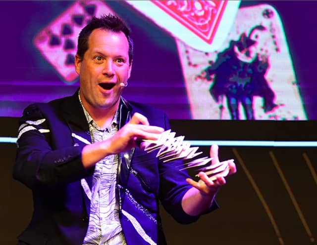 Farrell Dillon performing with a colorful stage backdrop